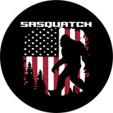 Sasquatch spare tire cover for Jeep, Bronco, campers, RV, van, and more. This spare tire cover design has Bigfoot walking through the forest with a rustic old glory, the American flag, as the background and the name Sasquatch written across the top.