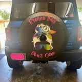 Bronco hair don't care saying with a silhouette of a girl with a messy bun wearing rainbow sunglasses and headband graphic on a spare tire cover for Ford Bronco