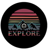 The word explore below a landscape silhouette of mountains and the sky or sun with layered jewel tones spare tire cover for campers, RV, Jeep, Broncos, and more  on black vinyl with a JL backup camera