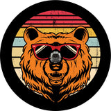 Spare tire cover for back up camera on black vinyl of red, yellow, and cream stripes in the background with a rustic vintage look and a bear head wearing sunglasses.