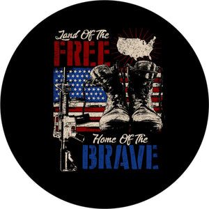 Patriotic spare tire cover design with images of a military rifle, boots, and a silhouette of the United States on top of an American flag and the quote, "land of the free home of the brave"