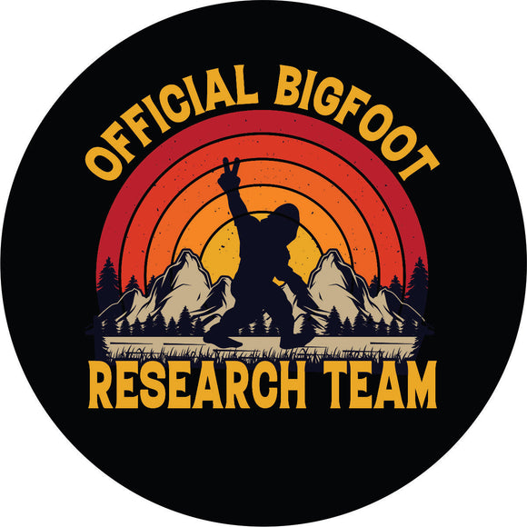 Sasquatch spare tire cover for Bronco, Jeep, RV, camper, and more with Bigfoot throwing out the peace sign as he walks along with mountains in the back and an ombre colored sunset. With the words, 